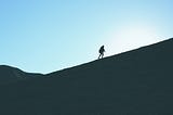A lone man climbing a mountainside
