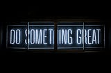 Bright neon sign reading: “DO SOMETHING GREAT”