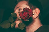 Man biting red rose in a closeup shot