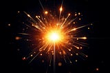 A bright, glowing sparkler against a dark background. The sparkler emits a burst of golden light with sparks radiating outward in all directions. The intense center of the sparkler is white-hot, gradually transitioning to a warm orange and gold as the sparks spread. Tiny glowing particles surround the sparkler, adding a dynamic and festive feel to the image.