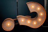 A slightly toppled lighted question mark