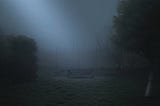 A bench sitting in a foggy park at night.