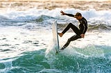 Man surfing, coming vertical off the lip of the wave