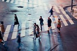 People walking in a crosswalk in a city.