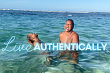 Amina and Tiara laughing outloud, standing in water at nude beach. The words “Live Authentically’ covers their nudity.