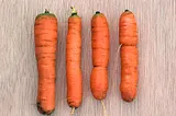 Photograph of four raw carrots.