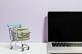 Cash in cart next to a laptop