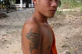 Monks, Baguettes and Rock & Roll (Eight Days in Laos): A Laotion Monk showing his tattoo.