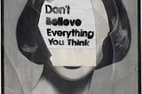 A black and white photo of a woman with a note covering her face saying ‘Don’t believe everything you think’.