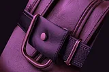 Close-up view of a luxurious purple leather handbag with a detailed rose gold buckle, exemplifying the high-resolution 3D product imaging capabilities by Designhubz for a sophisticated online retail experience.