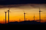 IMAGE: Several wind turbines gyrating on a sunset scene