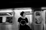 Annie Spratt took this black-and-white photo of a young woman standing on a subway platform looking to her left.