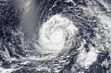 Cloud bands from Typhoon Mawar completely dwarf the island of Guam as the storm moves over the Pacific Ocean, as seen from space.