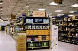 An educational display with a tablet playing content about beer, in a Schnucks Market grocery store.