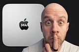 Mark Ellis on the right with his finger to his lips, looking intrigued and electric. Behind him is a giant M2 Mac Mini with ‘M4’ in the Apple logo.