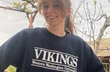 Smiling woman with hands on hips wearing a Western Washington University Vikings sweatshirt