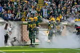 Aaron Rodgers leads the Green Bay Packers out of the Lambeau Field tunnel.