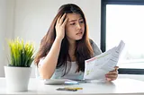 A woman reviewing bills, highlighting ADHD challenges in money management.