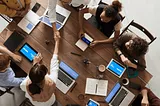 An overhead shot of eight people setting marketing goals at a table