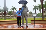 Image of myself, Hector Figueroa, sheltering the statue of Thomas Edison with an umbrella on FSW Lee Campus during a rainy day.