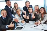 group of people in the office all with their thumbs up to represent toxic positivity