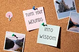 A photo of a bulletin board with sticky notes saying, “Turn your wounds into wisdom.”