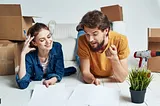 Couple happily creating moving checklist before the move