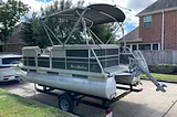 Misty Harbor pontoon boat on a trailer in the street