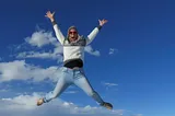 The author doing a jumping jack with only the sky in the background.