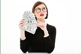 A photo of a young woman with a questioning look on her face holding a fan of hundred dollar bills.