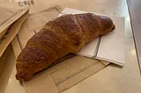 A French croissant laid out on a napkin.