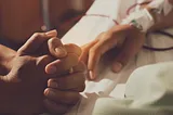 The hands of two people at the hospital