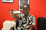 Lauryn Taiwo, A Leasing Manager at The Henry, Sitting At Her Desk Holding Up Her Name Tag!