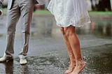 Bride and groom standing in rainwater