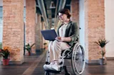 A woman sits in a wheelchair.