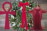 An evergreen Christmas wreath with a red southern tie style bow which mimics the ankh in the picture and the birthing Goddess in red with arms outstretched