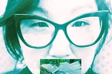 Face of Korean woman with butterfly frame glasses, and a picture of hands processing a DNA sample covering her mouth.