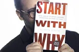 A picture of Simon Sinek covering his face with a copy of his book Start with Why