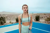 A woman working out on a basketball court.