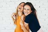 Two young women hugging and smiling