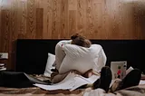 woman crying on a bed surrounded by paper