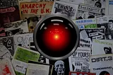 A collection of punk zines with the glaring eye of HAL 9000 from Kubrick’s ‘2001: A Space Odyssey’ in the center of the image. Image: Cryteria (modified) https://commons.wikimedia.org/wiki/File:HAL9000.svg CC BY 3.0 https://creativecommons.org/licenses/by/3.0/deed.en — Jake (modified) https://commons.wikimedia.org/wiki/File:1970s_fanzines_(21224199545).jpg CC BY 2.0 https://creativecommons.org/licenses/by/2.0/deed.en