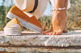 A woman wearing an anklet made out of cowrie shells