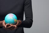 A woman holding a globe in her hands.