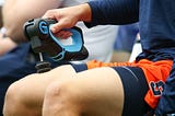 A Syracuse Orange player uses a TheraGun during warm ups prior to the game against the Connecticut Huskies.