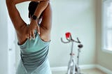 A woman stretching while wearing a smartwatch.