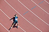 A tired runner lies down on a track.