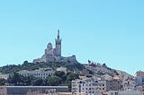 A photograph of the waterfront and a church in Marseille, France.