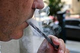 A closeup photo of a man exhaling smoke from an electronic cigarette in Washington, DC on September 12, 2019.