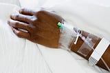 Closeup of hand of a patient at hospital with IV drip.